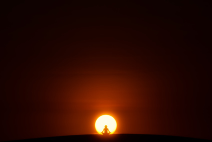 Meditation.A person is sitting in the Lotus pose in center of the Sun.