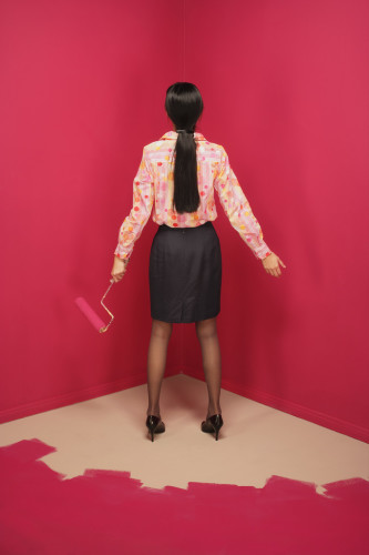 Rear view of a young woman holding a paint roller --- Image by © Royalty-Free/Corbis